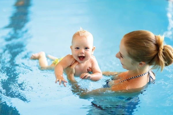 Mutter mit fröhlichen Säugling beim Babyschwimmen