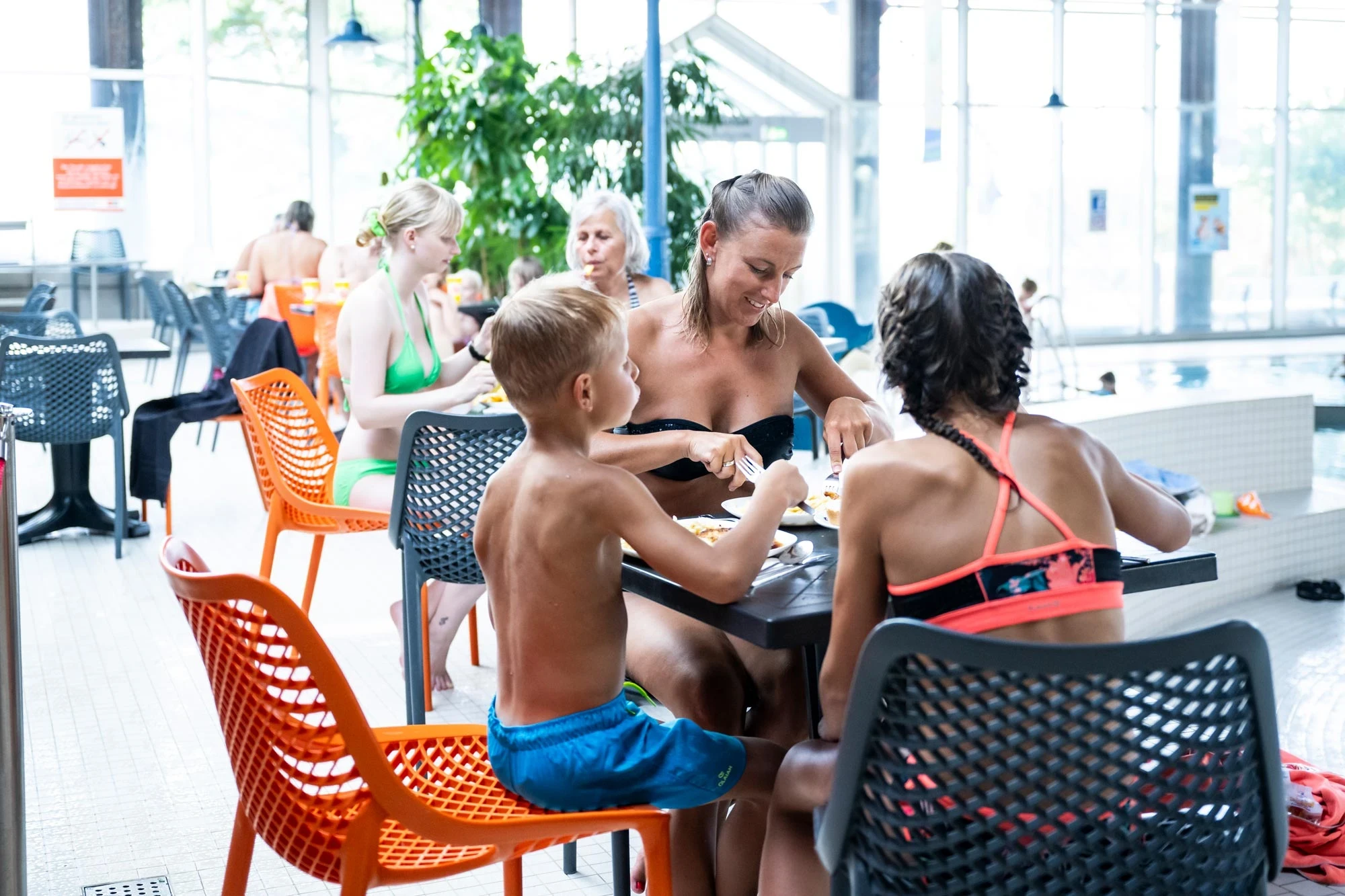 Mutter mit zwei Kindern macht Badepause in der Bikinibar mit Blick auf den Kleinkindbereich