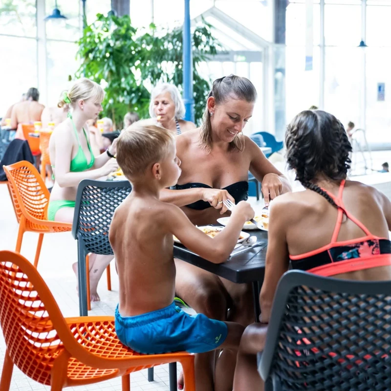 Eine Mutter mit zwei Kindern im Gastrobereich beim Essen.