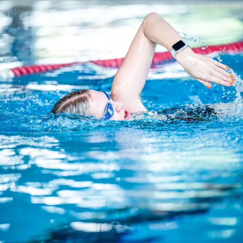 Eine junge Frau zieht ihre Bahnen im Sportbecken.