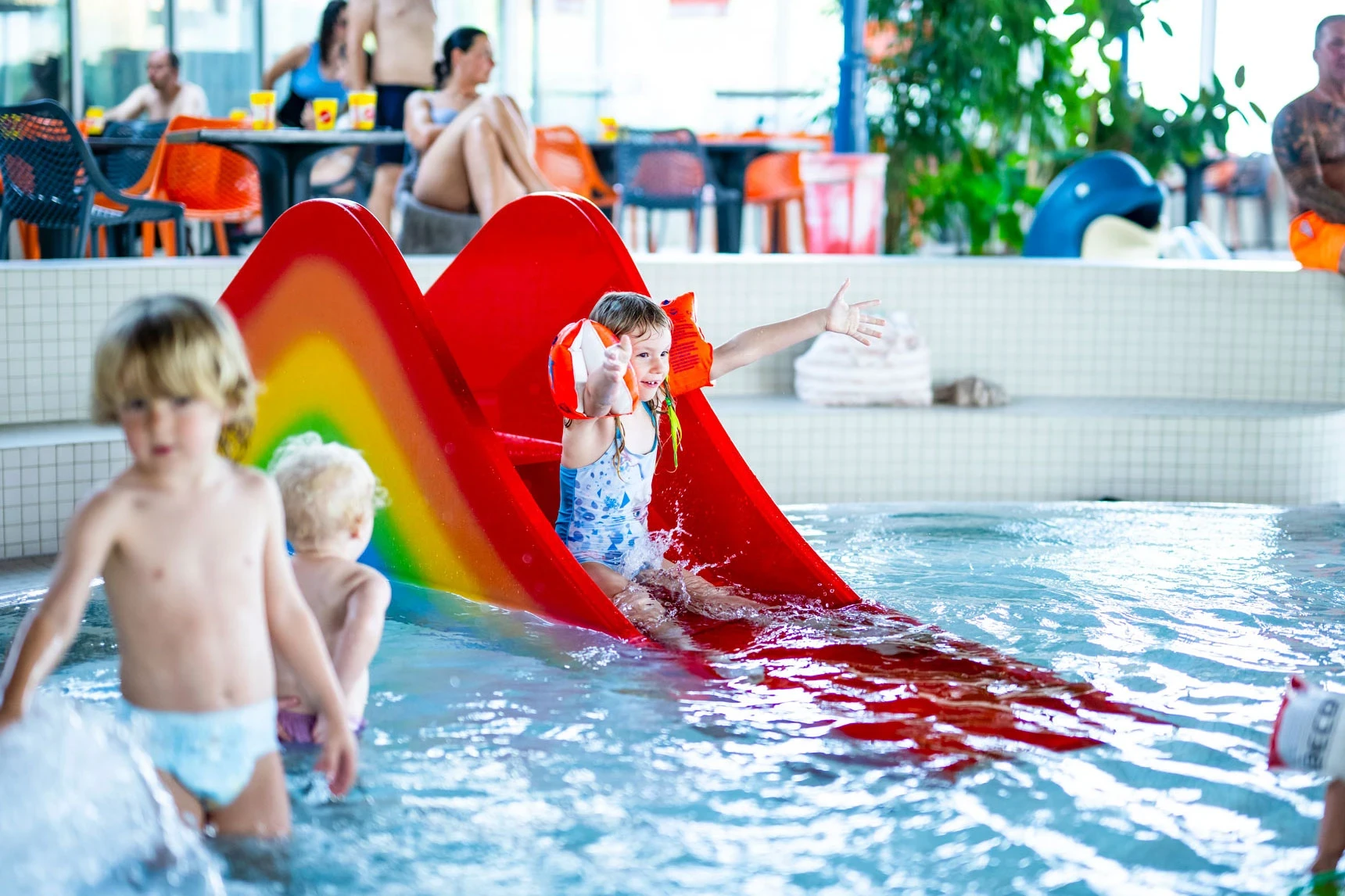 Kleine Kinder spielen im Kleinkindbereich im Hintergrund die Bikini-Bar.