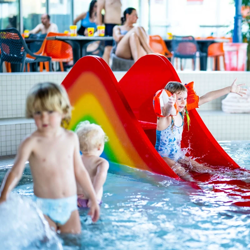 Kleine Kinder spielen im Kleinkindbereich im Hintergrund die Bikini-Bar.