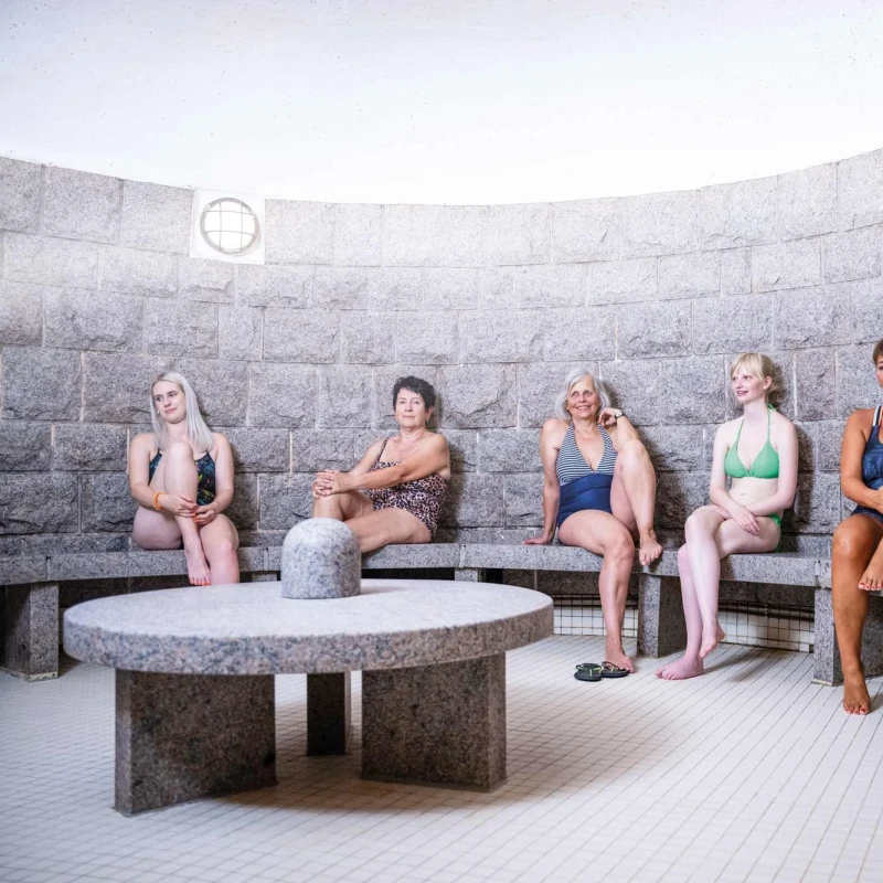 Frauen entspannen gemein in der warmen Dampfgrotte und profitieren von der gesunden hohen Luftfeuchtigkeit